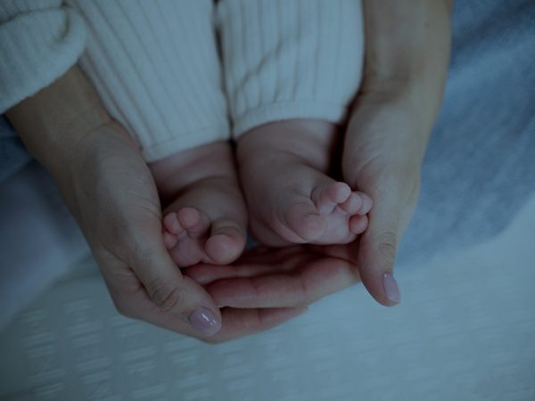 mãe segurando pé de um bêbe