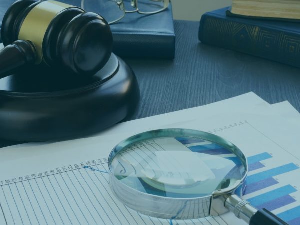 lupa sobre um documento ao lado de uma martelo de direito