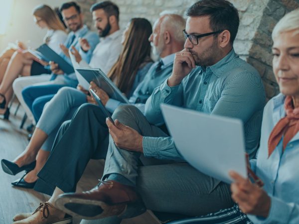 pessoas sentadas esperando entrevista de emprego