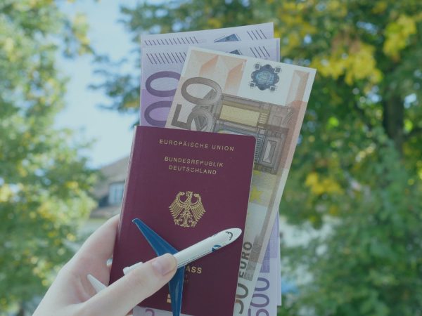 mao segurando um passaporte europeu com notas de euros