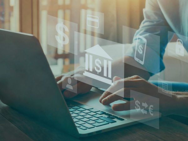 uma pessoa usando o laptop com imagens de banco e cifrão aparecendo de forma virtual na tela