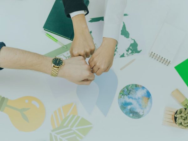três mãos se tocando encima de uma mesa